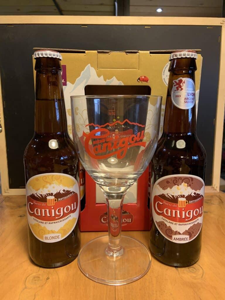Deux bouteilles de bière Canigou et un verre dans un décor montagne chic.