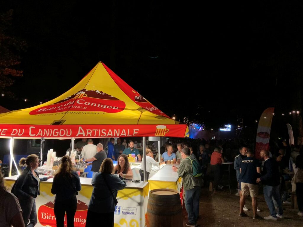 Les gens se rassemblent autour de la tente "Bière du Canigou".