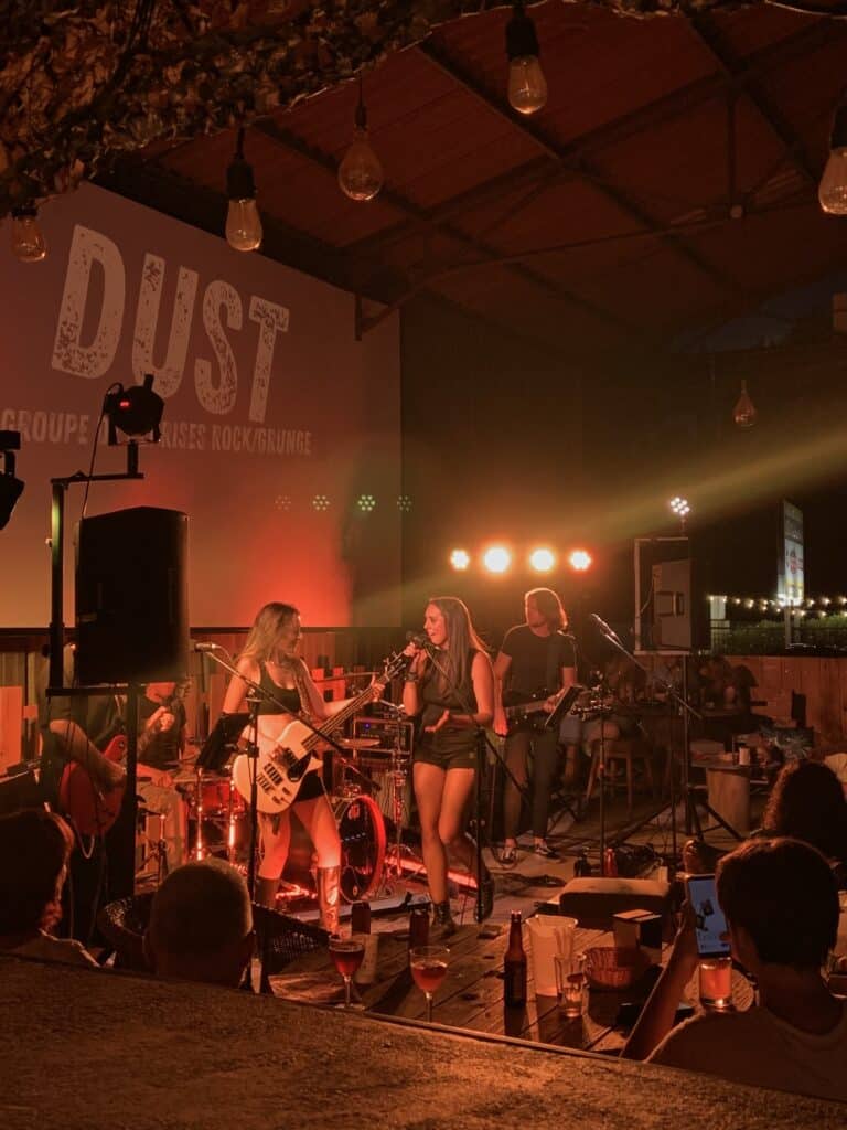 Un groupe de rock électrise une salle de charme, captivant avec des rythmes et une énergie tamisée.