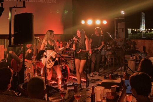 Un groupe de rock électrise une salle de charme, captivant avec des rythmes et une énergie tamisée.