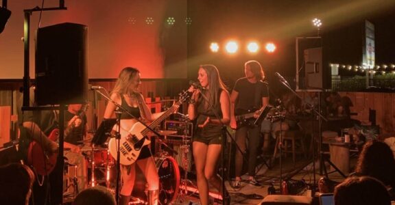 Un groupe de rock électrise une salle de charme, captivant avec des rythmes et une énergie tamisée.